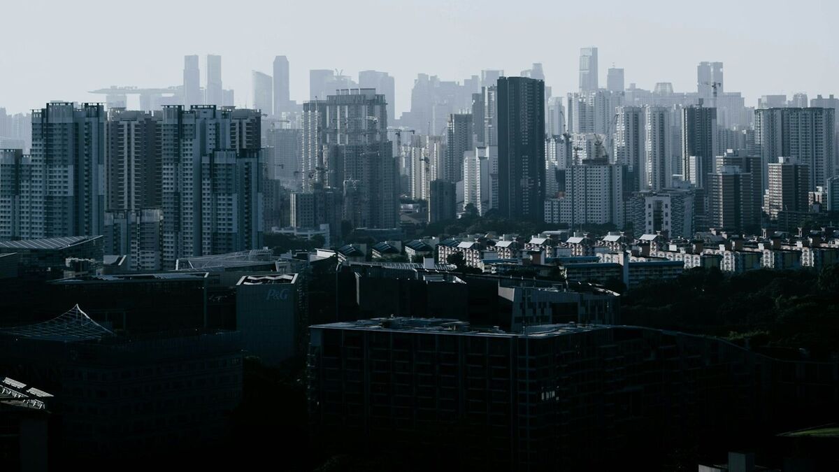 A hazy skyline of densely packed high-rise apartment and office towers.
