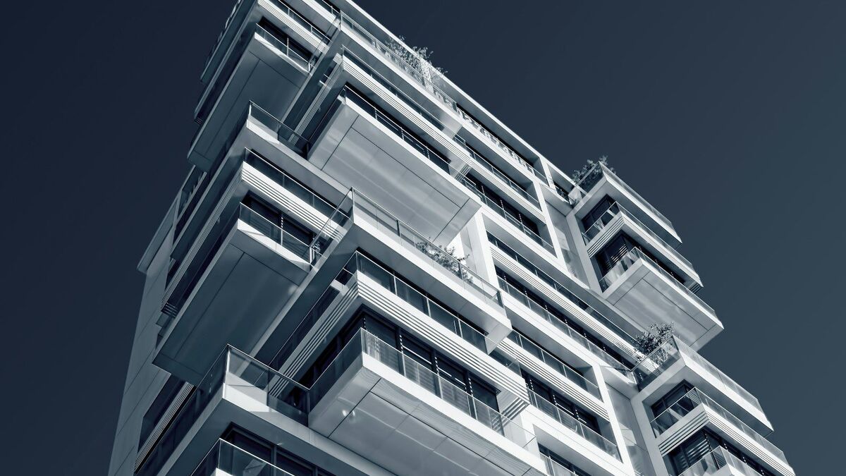 Low-angle view of a modern residential apartment building with stacked balconies.